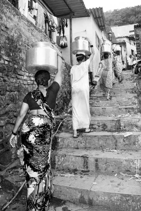 Women and Drinking Water Challenges - Women carrying headloads of drinking water procured from a group connection in a hilly locality in Mumbai, Maharashtra
